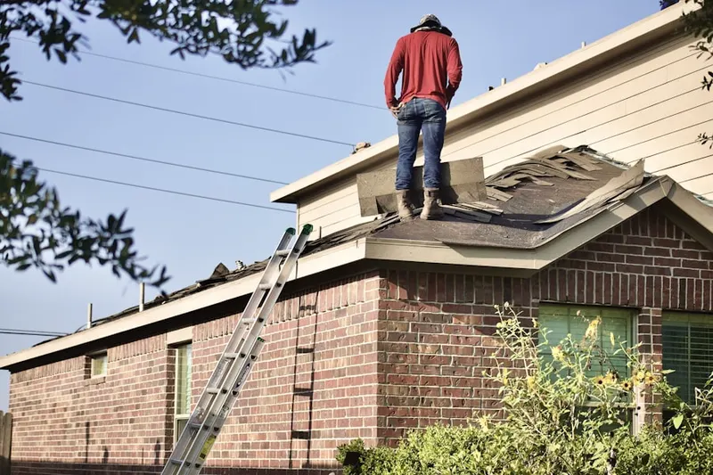 Professional roofer working on a residential roof in Mettler